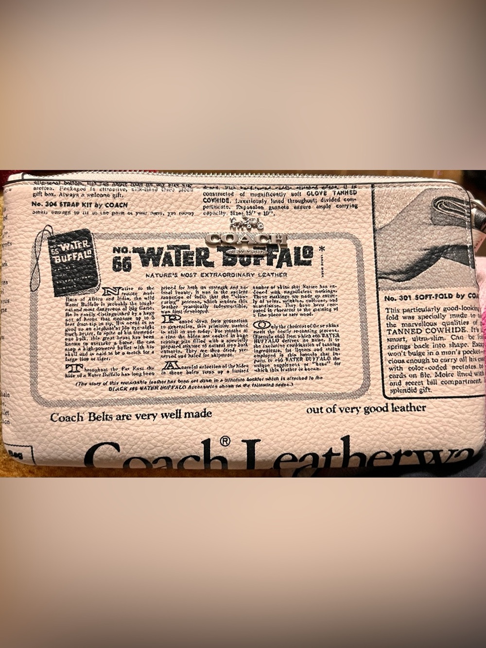 Coach Corner Zip Wristlet featuring a unique "Newspaper Print" design